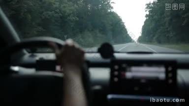自信的女<strong>司机</strong>驾驶汽车在乡村道路上通过森林从内部的车辆内部的观点